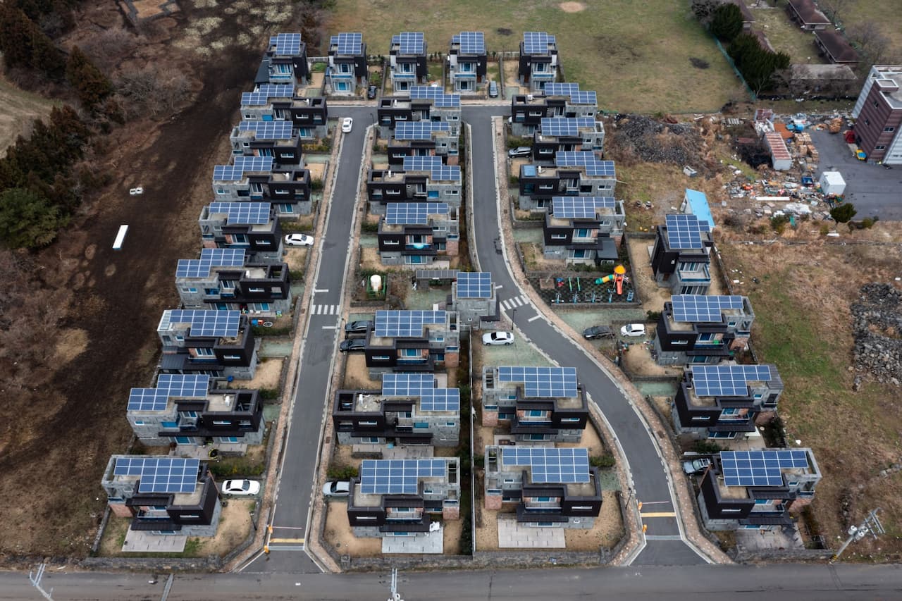 済州島の住宅の屋根に設置されたソーラーパネル。住民は、本土から運ばなければならないエネルギーに高い料金を支払っており、そのコストを下げることを切望しています。写真家 SeongJoon Cho/Bloomberg